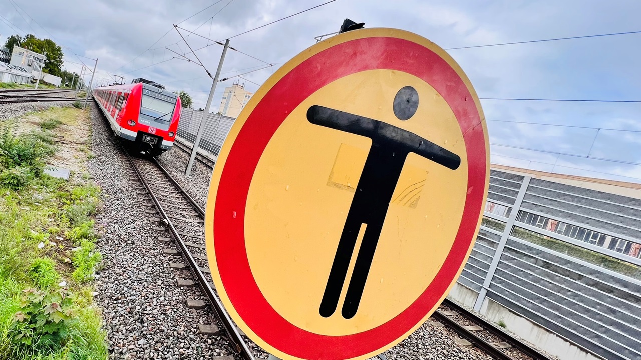 Durchgang Verboten Schild Ein Warnschild mit einem stilisierten Menschensymbol neben Schienen.